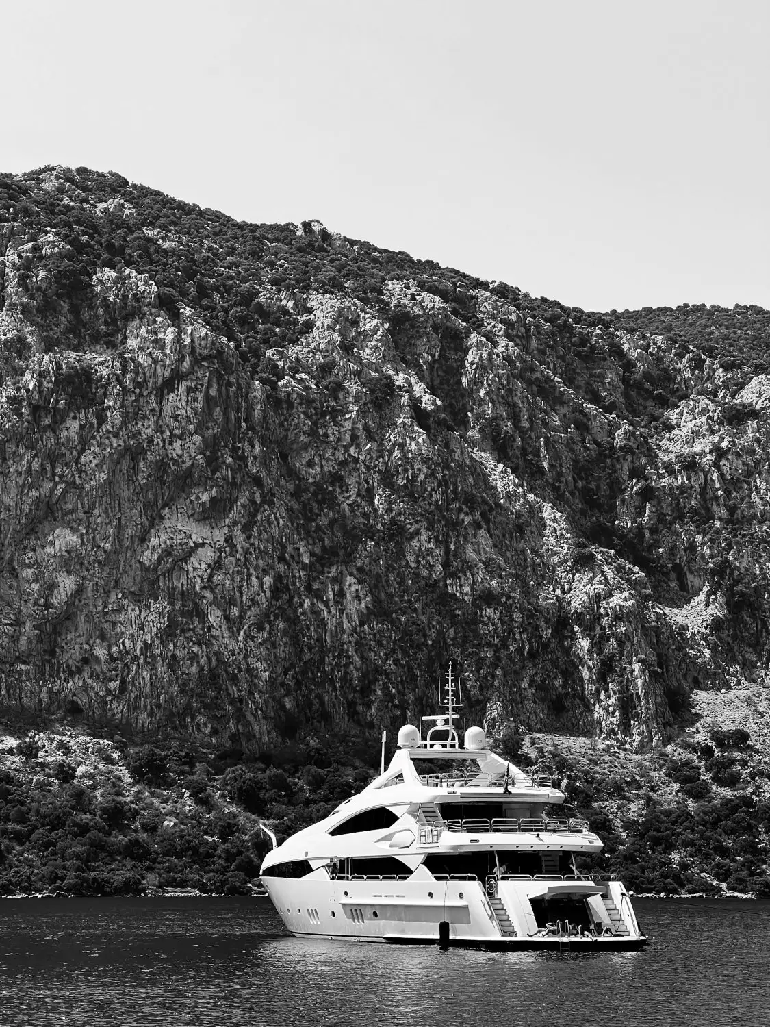 A luxury yacht sailing on a serene lake surrounded by mountains, symbolizing a peaceful and affluent retirement.